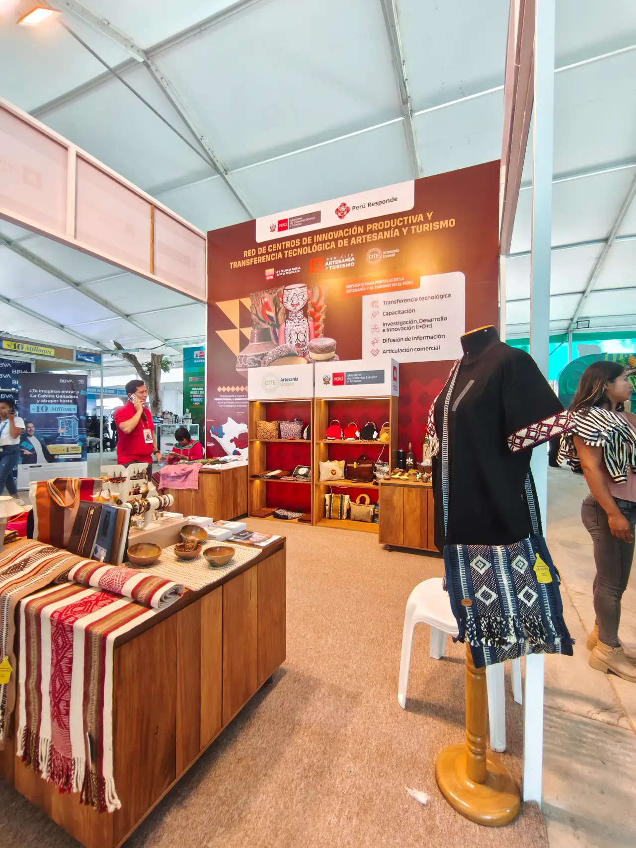 Caminos de mesa tejidos en telar y una blusa negra con mangas bordadas en el stand